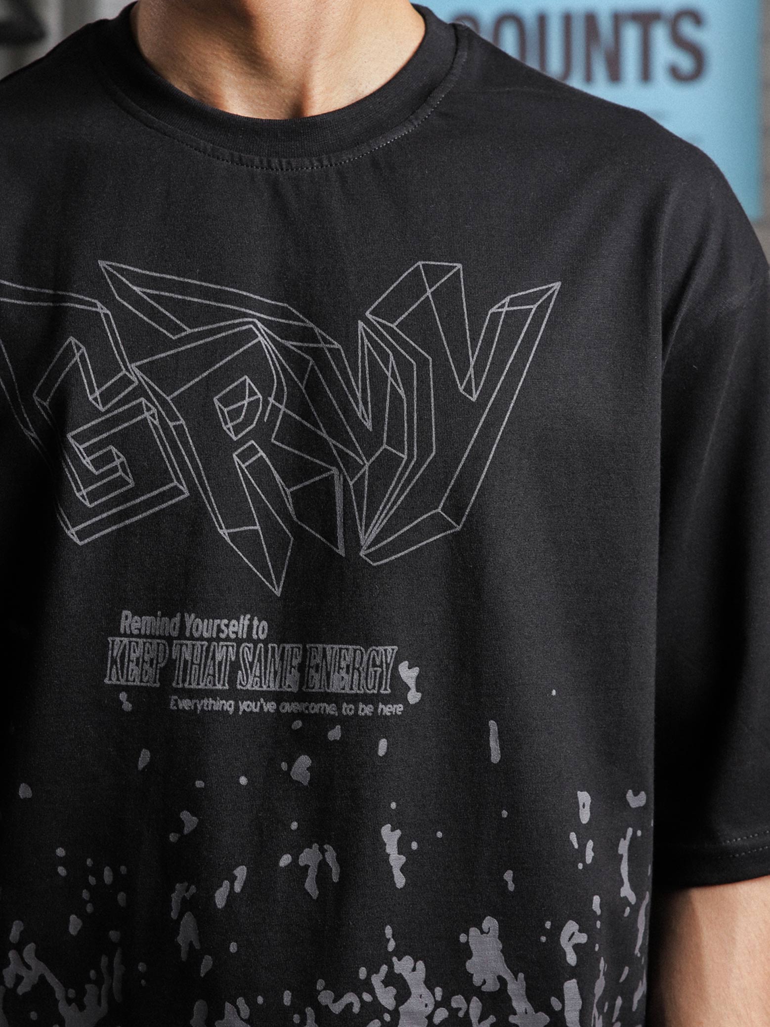 Close-up of GRVY logo and “Keep That Same Energy” print on black heavy-weight streetwear t-shirt, captured on male model.