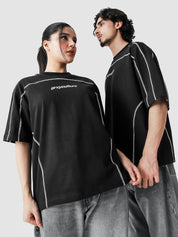 Two people wearing black t-shirts with white text on a plain background