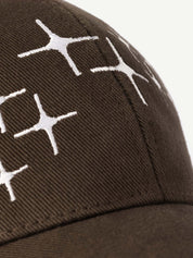 Brown cap with white geometric pattern on a light gray background