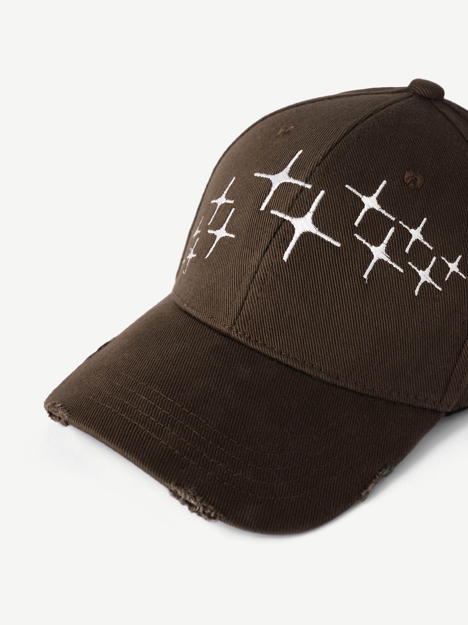 Brown cap with white geometric pattern on a light gray background