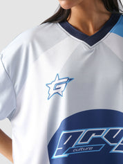 Woman wearing oversized blue and white racing jersey with bold graphics – Groovy Culture unisex streetwear shot in lifestyle indoor setup Pakistan
