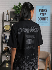 Close-up of back graphic on black oversized t-shirt featuring “Groovy Effect” and “Love Over Fear” typography, screenprinted in grey ink.