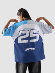 Back view of woman wearing oversized racing jersey with number 25 and Groovy Culture logo – indoor lifestyle streetwear shoot in Pakistan
