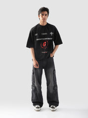 Male model posing in "GROOVY Energy" oversized t-shirt and washed black cargo pants – unisex streetwear t-shirt in Pakistan.