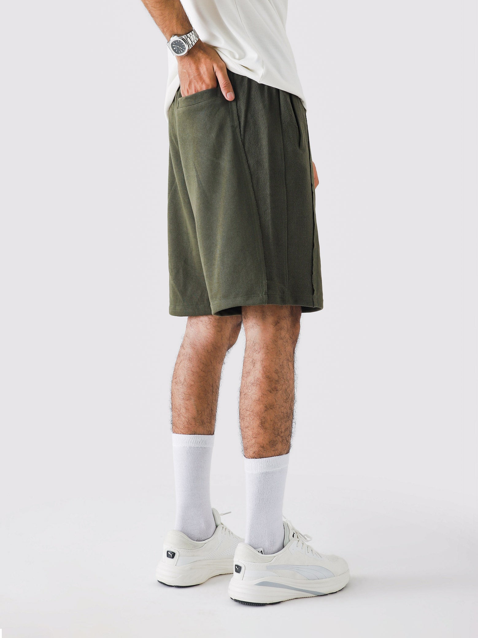 Military Green Aim Shorts on model, relaxed-fit men's gym and casual shorts by GROOVY Pakistan