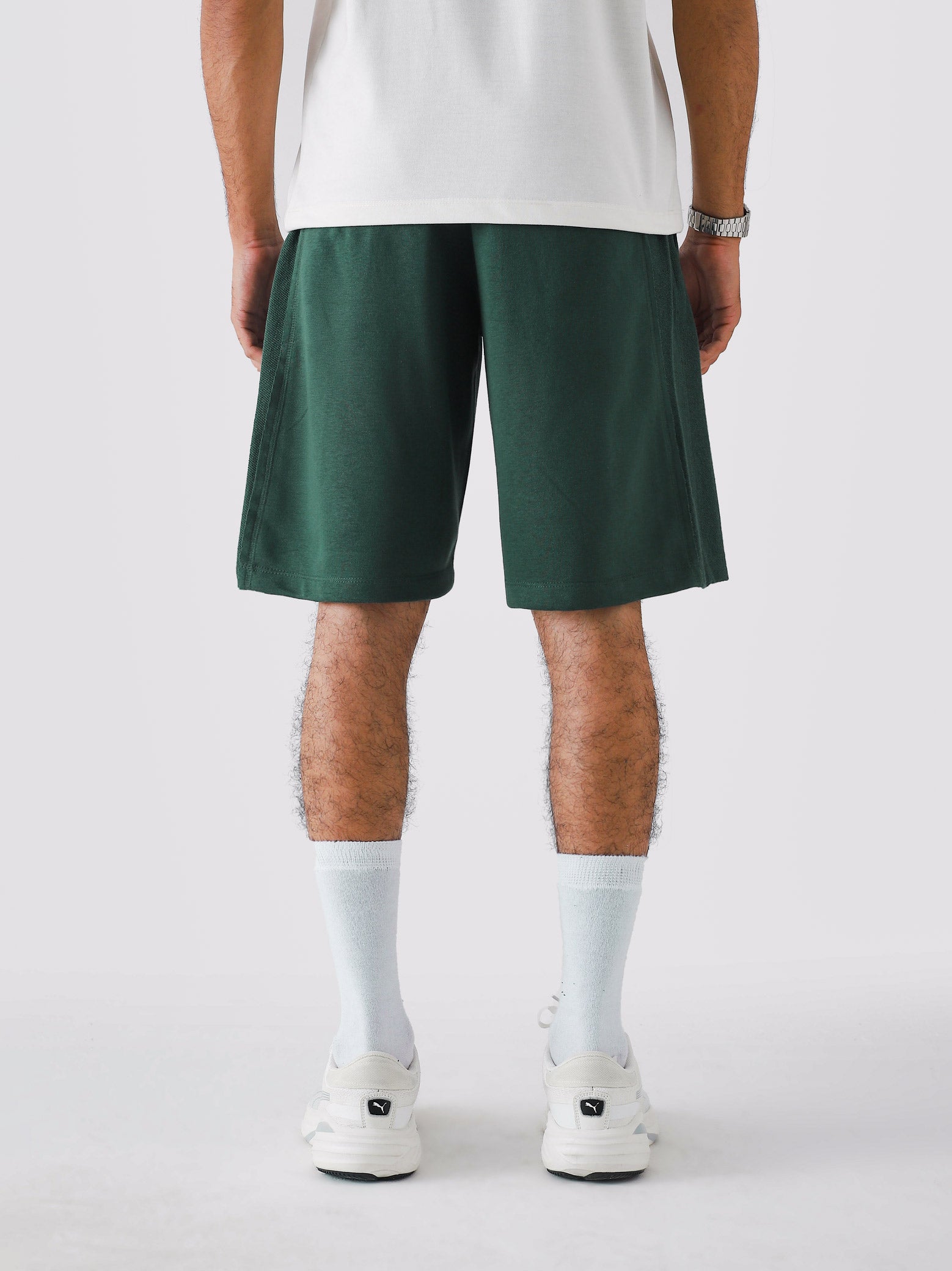 Deep Green Aim Shorts on model, relaxed-fit men's gym and casual shorts by GROOVY Pakistan