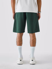 Deep Green Aim Shorts on model, relaxed-fit men's gym and casual shorts by GROOVY Pakistan