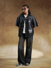 Washed black shirt worn open over a cream tee - GROOVY Pakistan