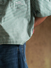 Green check shirt worn open over a cream tee - GROOVY Pakistan
